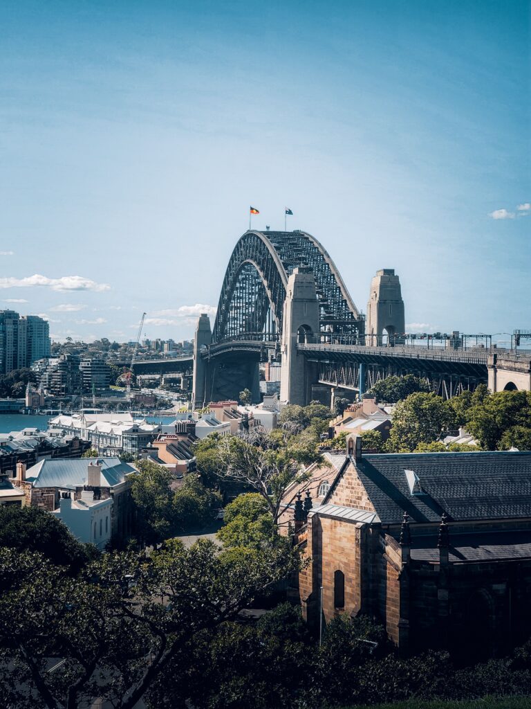 A vibrant view of the Sydney Harbor Bridge under a clear blue sky in Sydney, Australia.